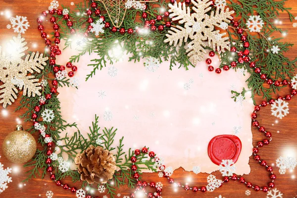 Рамка з вінтажним папером та різдвяними прикрасами на дерев'яному фоні — стокове фото