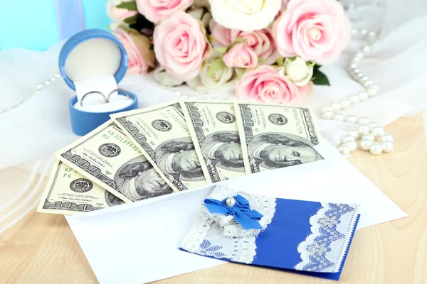 Dollar bills in envelope as gift at wedding on wooden table close-up — Stock Photo, Image