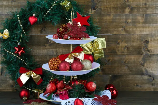 Christmas decorations on dessert stand, on wooden background — Stock Photo, Image