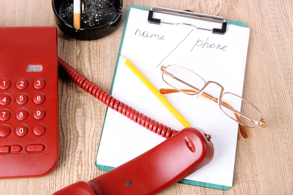 Telefono e blocco note e altri oggetti, su sfondo di legno — Foto Stock