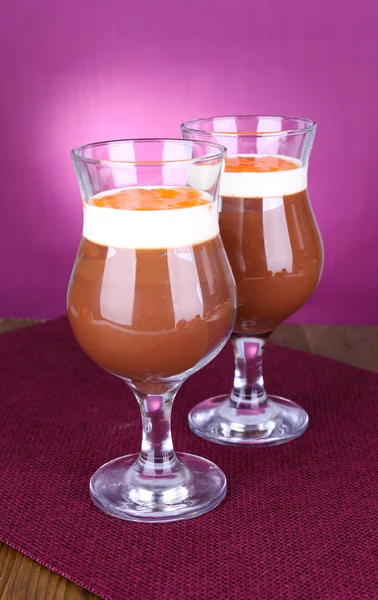 Sobremesa de chocolate e cáqui na mesa sobre fundo roxo — Fotografia de Stock