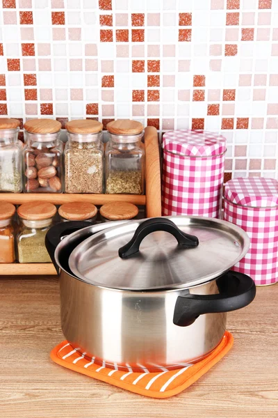 Pentola e spezie in cucina sul tavolo su sfondo piastrelle a mosaico — Foto Stock