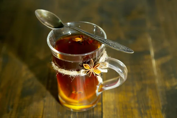 Warme drank in glas cup met vruchten en specerijen, op houten achtergrond — Stockfoto