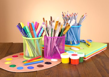 Masanın üzerine bej renkli arka plan üzerinde çeşitli yaratıcı araçlar bileşimi