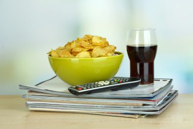 kase, cola ve tv uzaktan oda zemin üzerine tahta masada çipleri