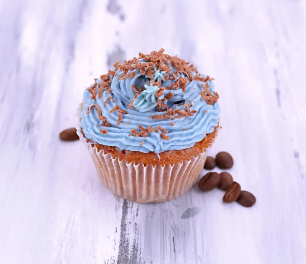 Leckere Cupcake mit Buttercreme, auf farbigem Holzhintergrund — Stockfoto