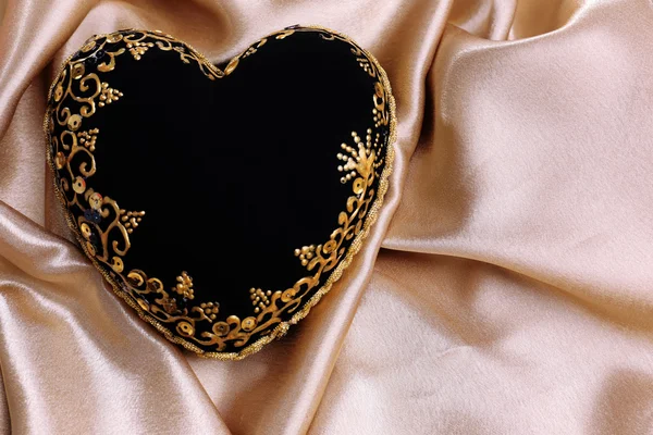 Decorative black heart, on color fabric — Stock Photo, Image