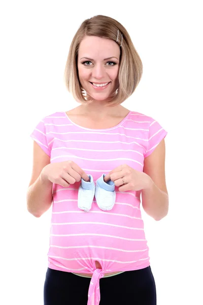 Young pregnant woman holding blue baby shoes isolated on white — Stock Photo, Image