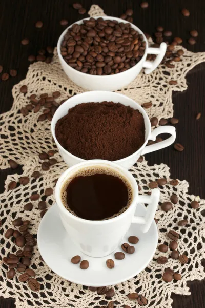 Diferentes tipos de café em três xícaras em mesa de madeira — Fotografia de Stock