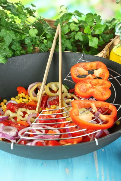 Légumes dans wok sur table en bois sur fond naturel — Photo