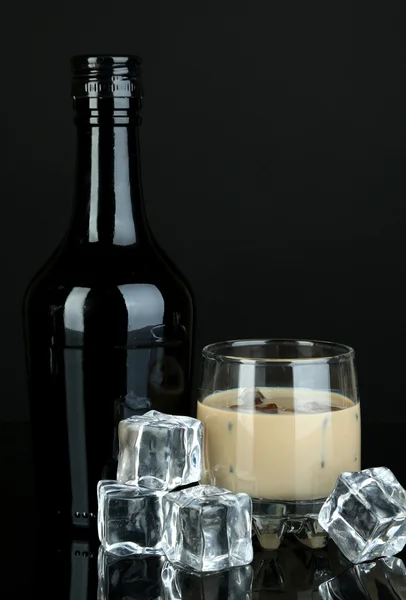 Baileys liqueur in bottle and glass isolated on black — Stock Photo, Image