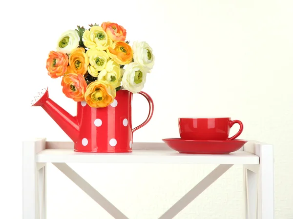 Blumen mit Tasse Tee auf weißem Regal auf grauem Hintergrund — Stockfoto