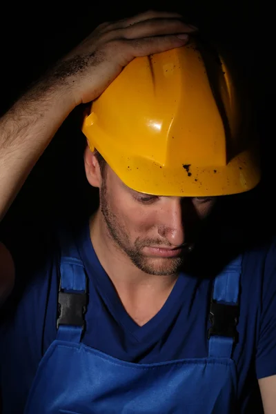 Portrait of young worker on dark background — Stock Photo, Image