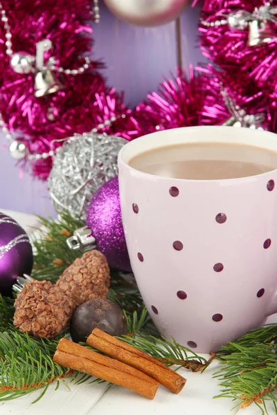 Coupe de cacao chaud avec chocolats et décorations de Noël sur table sur fond en bois — Photo