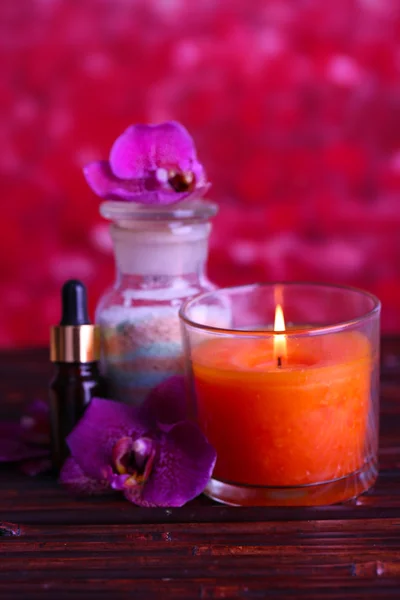 Beautiful spa setting with orchid on bamboo table on red background — Stock Photo, Image