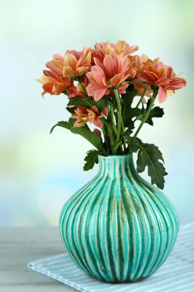 Flori frumoase în vază, pe masă de lemn, pe fundal deschis — Fotografie, imagine de stoc