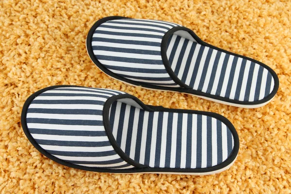 Zapatillas a rayas sobre fondo de alfombra — Foto de Stock