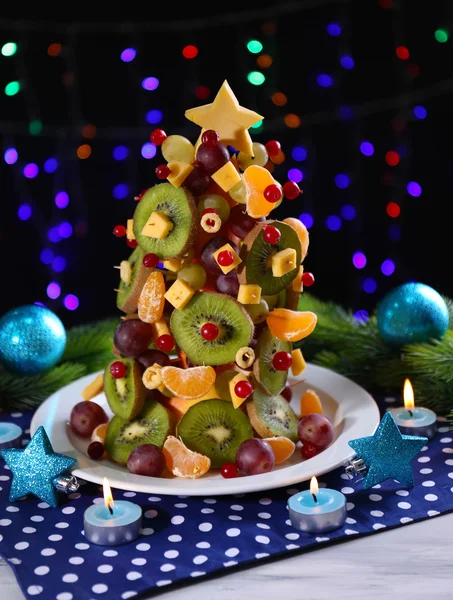 Árbol de Navidad de frutas en la mesa sobre fondo oscuro — Foto de Stock