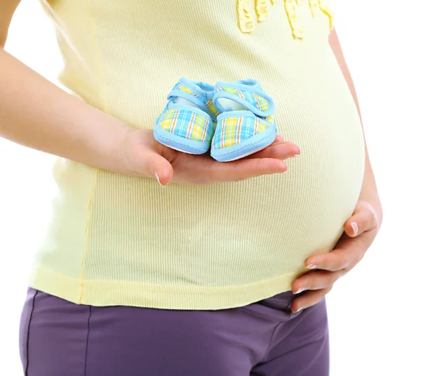 Mujer embarazada sosteniendo zapatos de bebé azules aislados en blanco —  Fotos de Stock