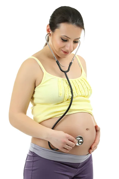 Jeune femme enceinte avec stéthoscope écoute bébé isolé sur blanc — Photo