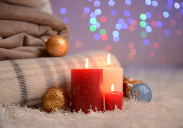 Sammansättning med plädar, ljus och juldekorationer, på vita mattan på ljus bakgrund — Stockfoto