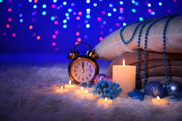 Composition avec plaids, bougies et décorations de Noël, sur tapis blanc sur fond lumineux — Photo