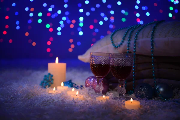 Композиція з пледами, свічками та різдвяними прикрасами, на білому килимі на яскравому фоні — стокове фото