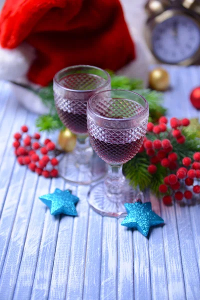 Copos de vinho e decoração de Natal no fundo brilhante — Fotografia de Stock