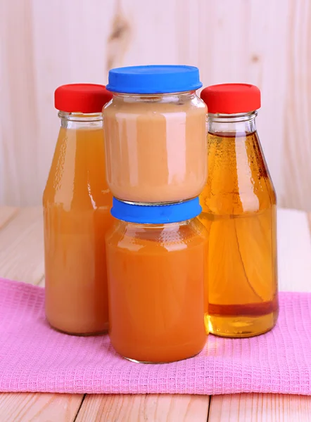 Frascos de varios alimentos para bebés, sobre fondo de madera — Foto de Stock