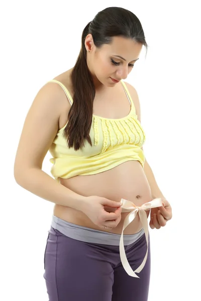 Young pregnant woman with beige bow on belly isolated on white Royalty Free Stock Photos