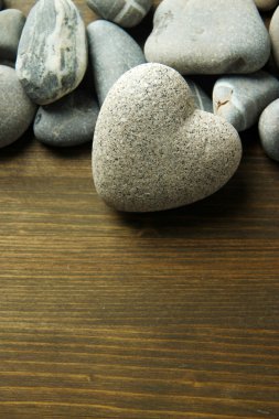 ahşap zemin üzerinde kalp şeklinde gri taş