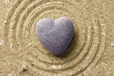 Gri zen stone kum arka plan üzerinde kalp şeklinde