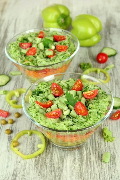 Smakelijke Salade met verse groenten op houten tafel — Stockfoto