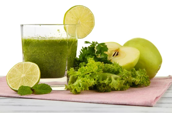 白い背景の上の木製のテーブルの上の緑の野菜ジュースのガラス — ストック写真