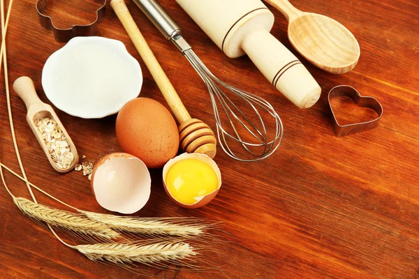 Concepto de cocina. Ingredientes básicos para hornear y utensilios de cocina en mesa de madera — Foto de Stock