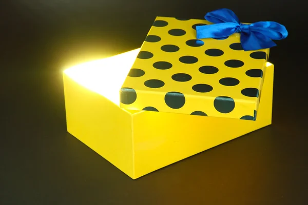 Geschenkbox mit hellem Licht auf dunkelgrauem Hintergrund — Stockfoto