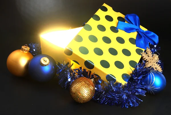 Caja de regalo con luz brillante sobre fondo gris oscuro —  Fotos de Stock