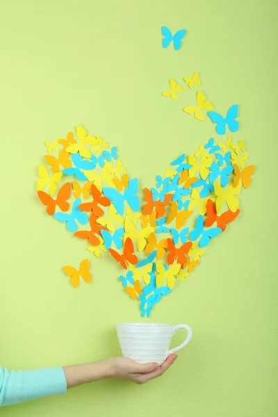 Mariposas de papel vuelan fuera de la taza sobre fondo de pared verde — Foto de Stock