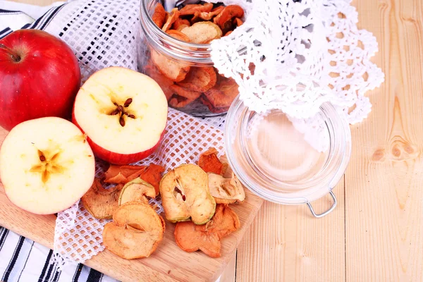 Gedroogde appels in glazen pot, op een houten achtergrond kleur — Stockfoto