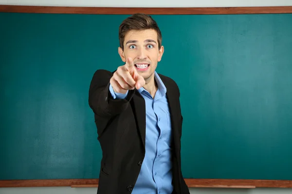 Joven profesor cerca de pizarra en el aula escolar —  Fotos de Stock