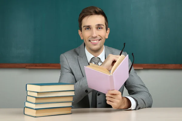 Unga lärare sitter i skola klassrum — Stockfoto