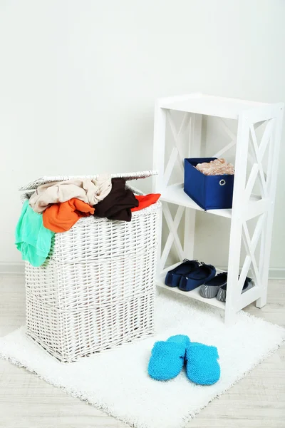 Panier à linge complet sur sol en bois sur fond intérieur de la maison — Photo