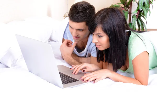 Couple in love with laptop in bed — Stock Photo, Image