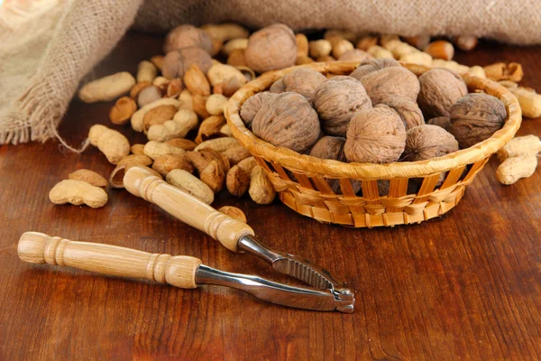Louskáček s ořechy na dřevěný stůl detail — Stock fotografie