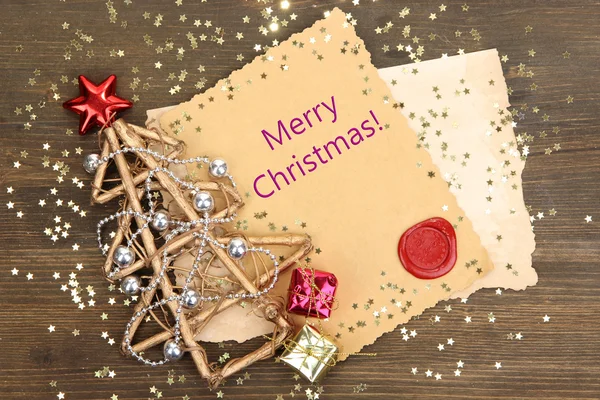 Рамка з вінтажним папером та різдвяними прикрасами на дерев'яному фоні — стокове фото
