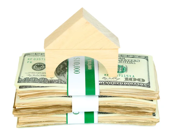 Wooden house on packs of dollars isolated on white — Stock Photo, Image