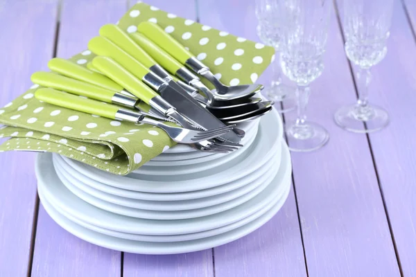 Clean dishes on wooden table on color background — Stock Photo, Image