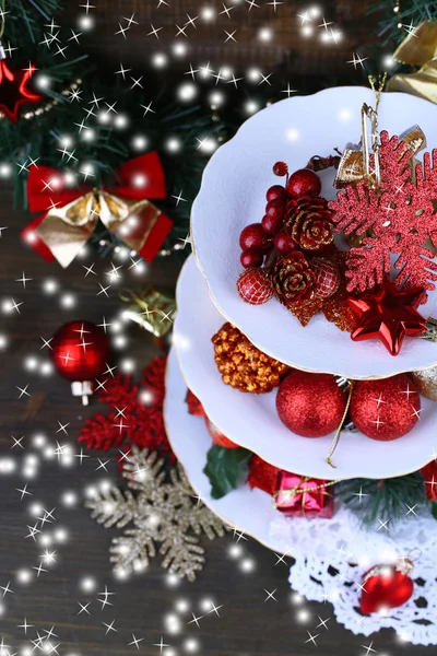 Decorazioni natalizie su supporto da dessert, su sfondo di legno — Foto Stock