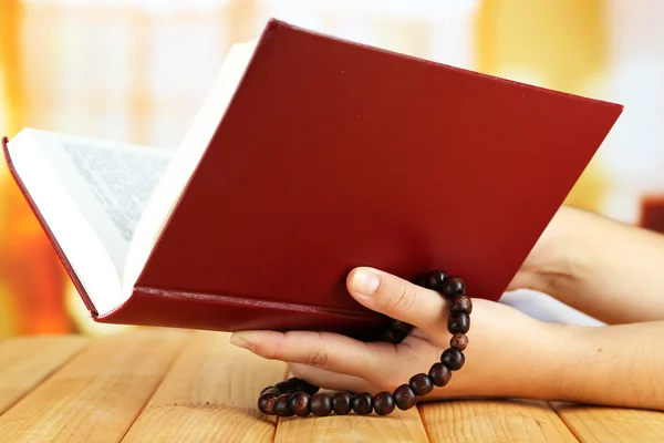 Mãos com rosário e livro sagrado, sobre fundo claro — Fotografia de Stock