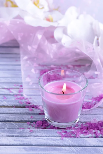 Hermosas velas de colores y flores de orquídea, sobre fondo de madera de color — Foto de Stock